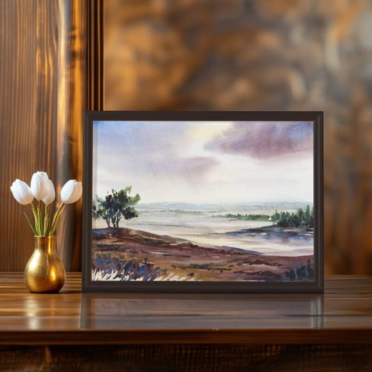 “Beulah,” an original landscape painting by Tara Shoemaker, framed and displayed on a dark wood surface beside white tulips in a gold vase; warm, moody lighting highlights the painting’s depth and contrast.