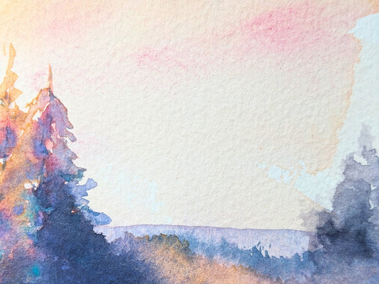 A detail shot of a watercolor landscape with colorful conifer trees under a soft peach and pink sky from Tara Shoemaker Art.