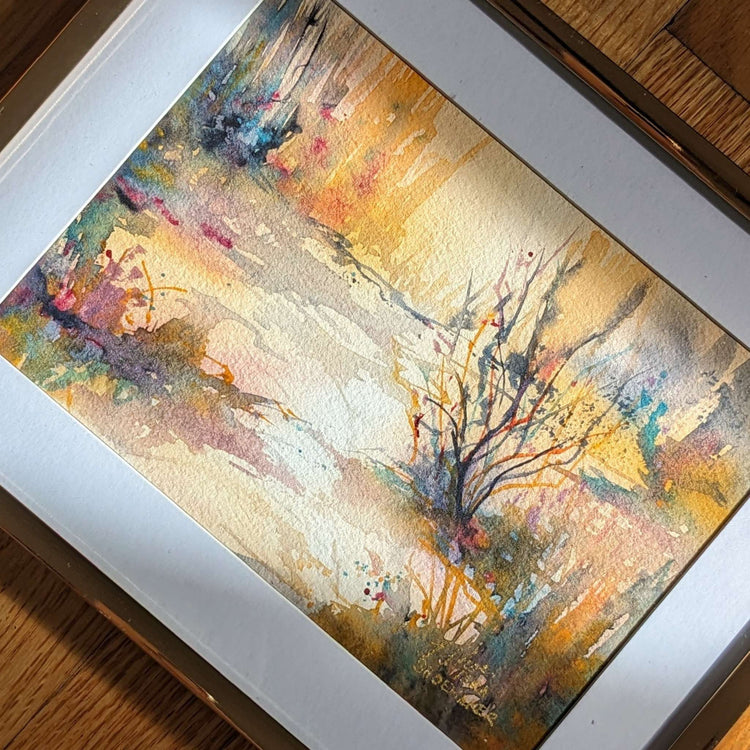 A golden abstract landscape painting in sunlight on the floor