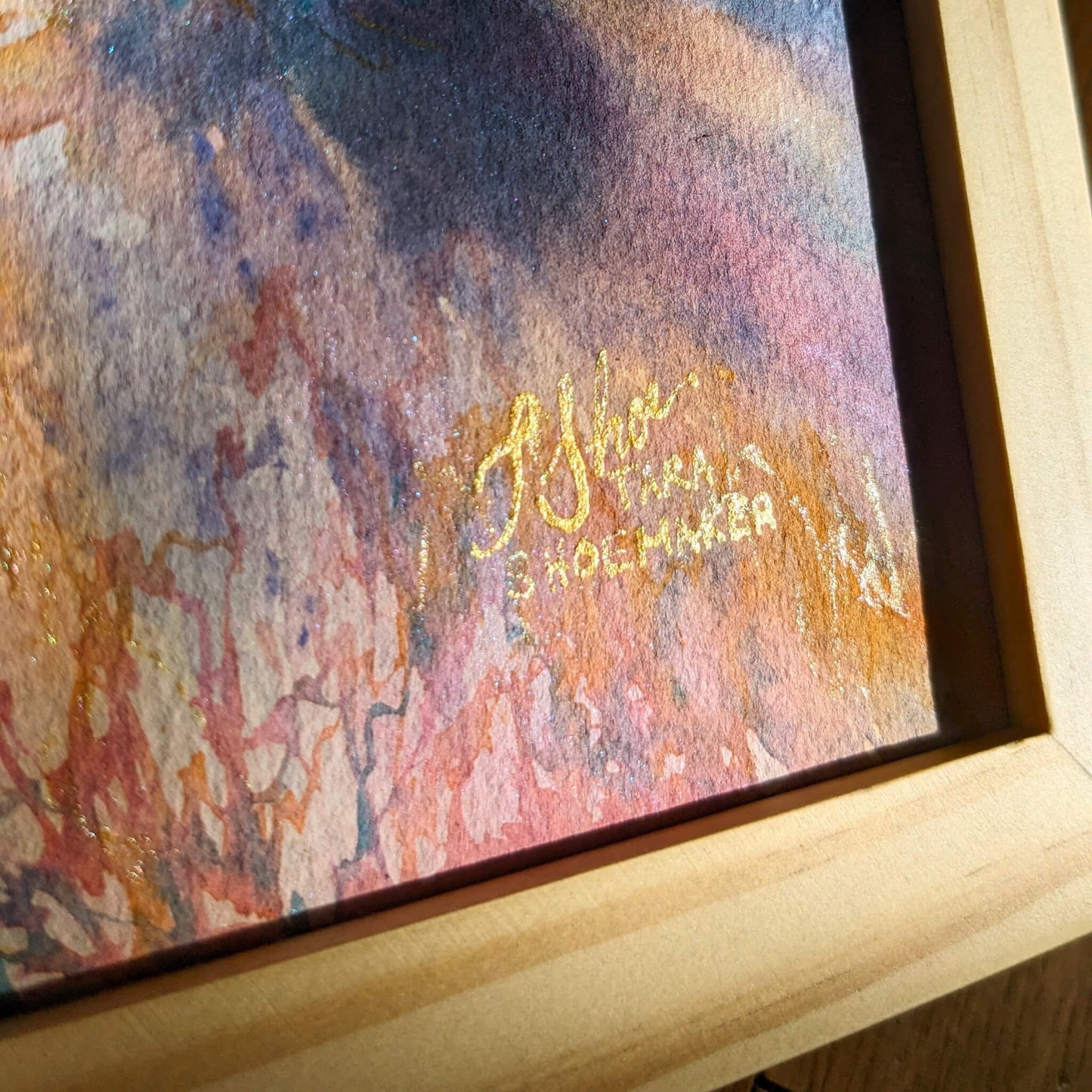 Framed abstract artwork with a signature on a textured surface