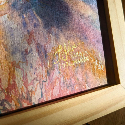 Framed abstract artwork with a signature on a textured surface