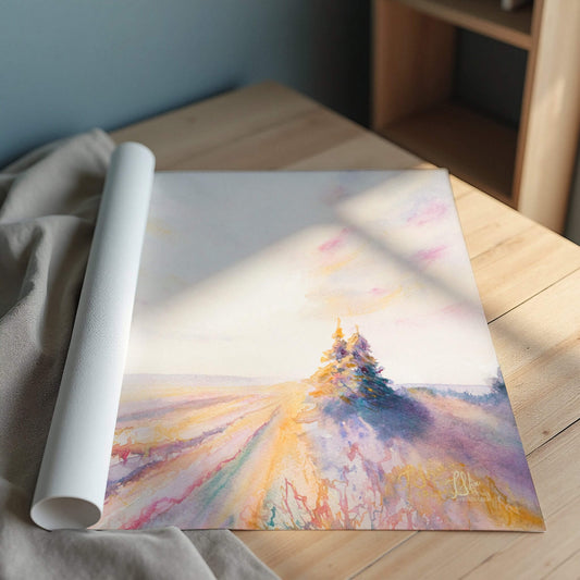 Rolled-up art print of a landscape with trees on a wooden surface.