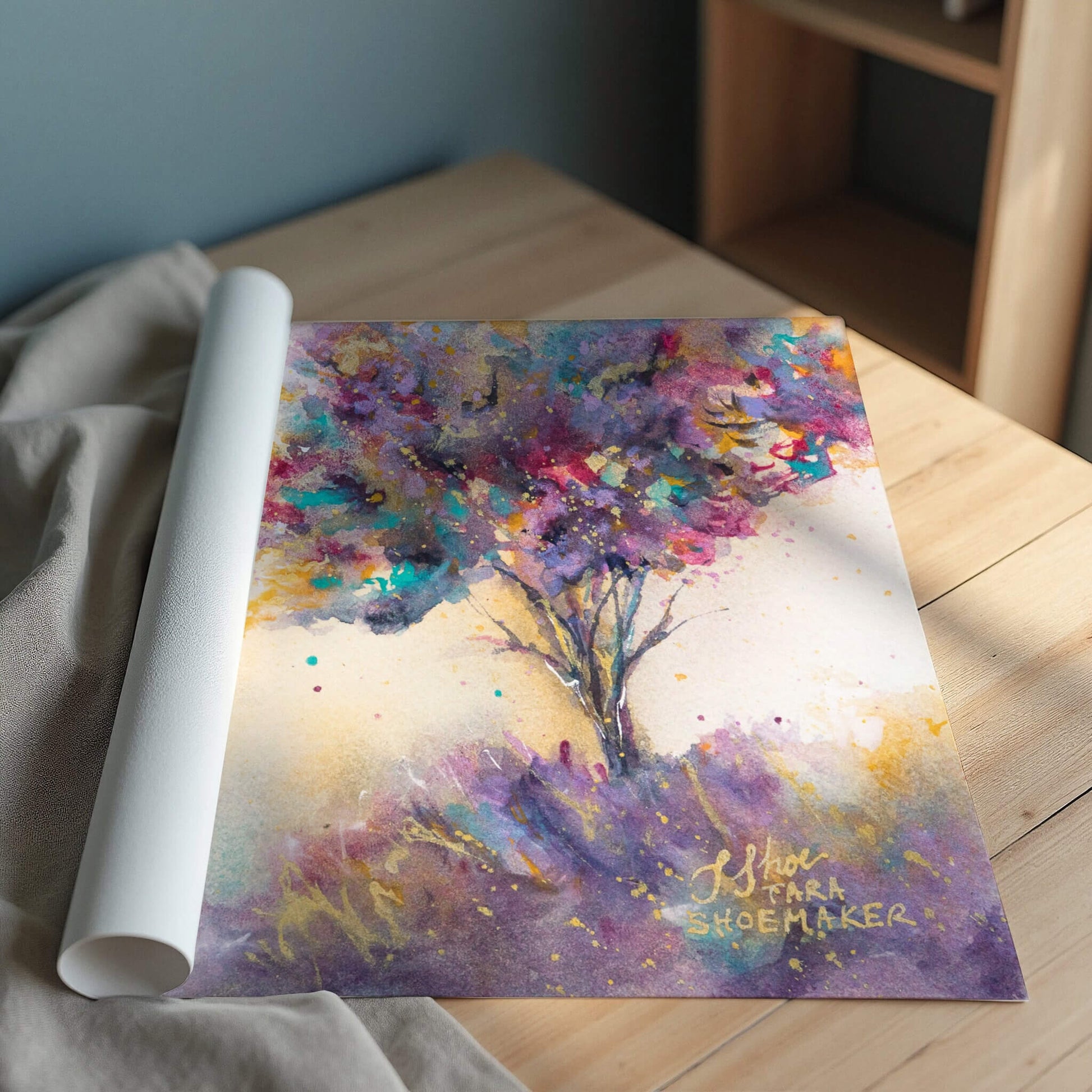 Colorful abstract art print of a tree on a wooden surface