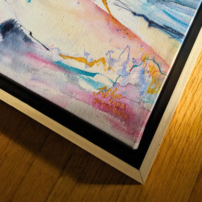 Close-up of a colorful abstract painting with a signature on a wooden surface