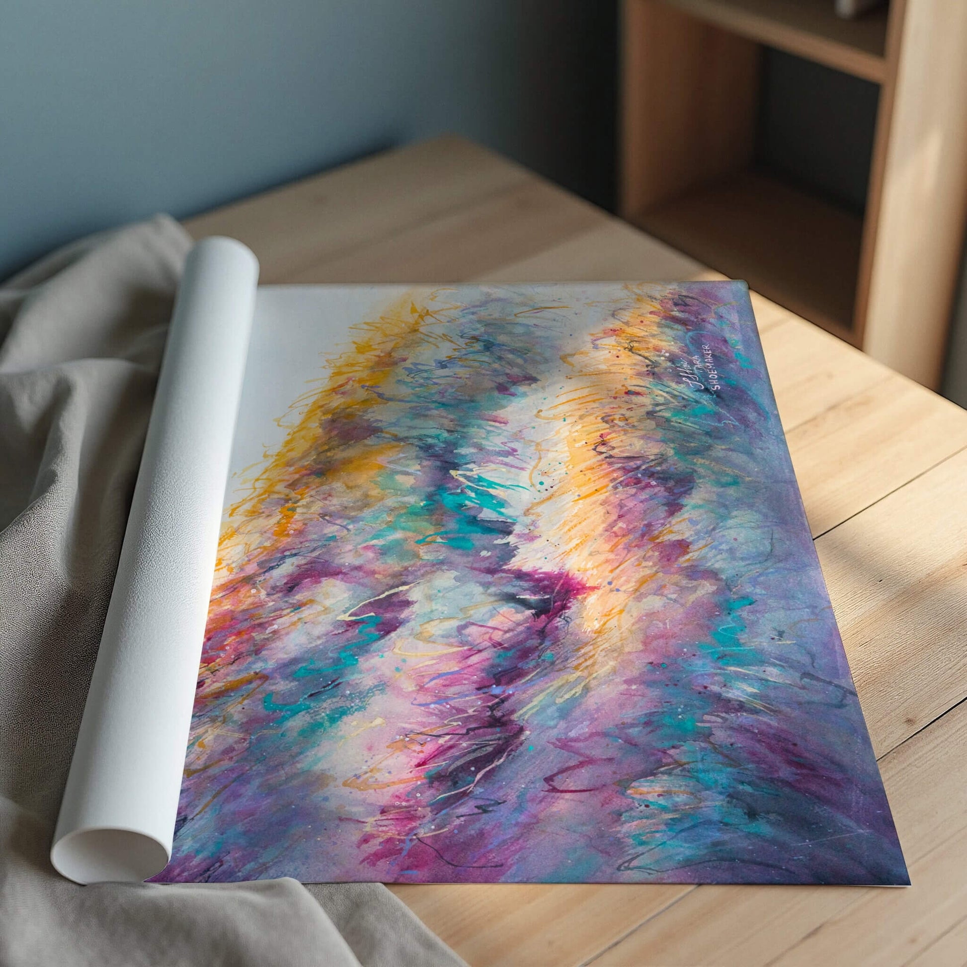 Rolled-up print of a watercolor painting with vibrant colors on a wooden surface