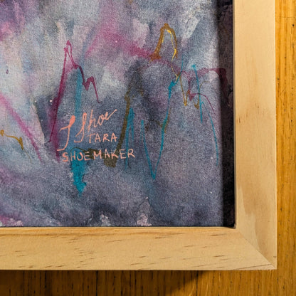 Abstract painting with colorful brush strokes and a signature on a wooden surface